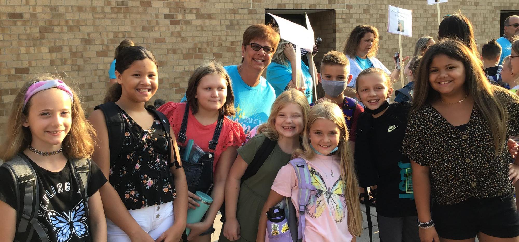 Fourth Grade Students and teacher standing outside of the school.