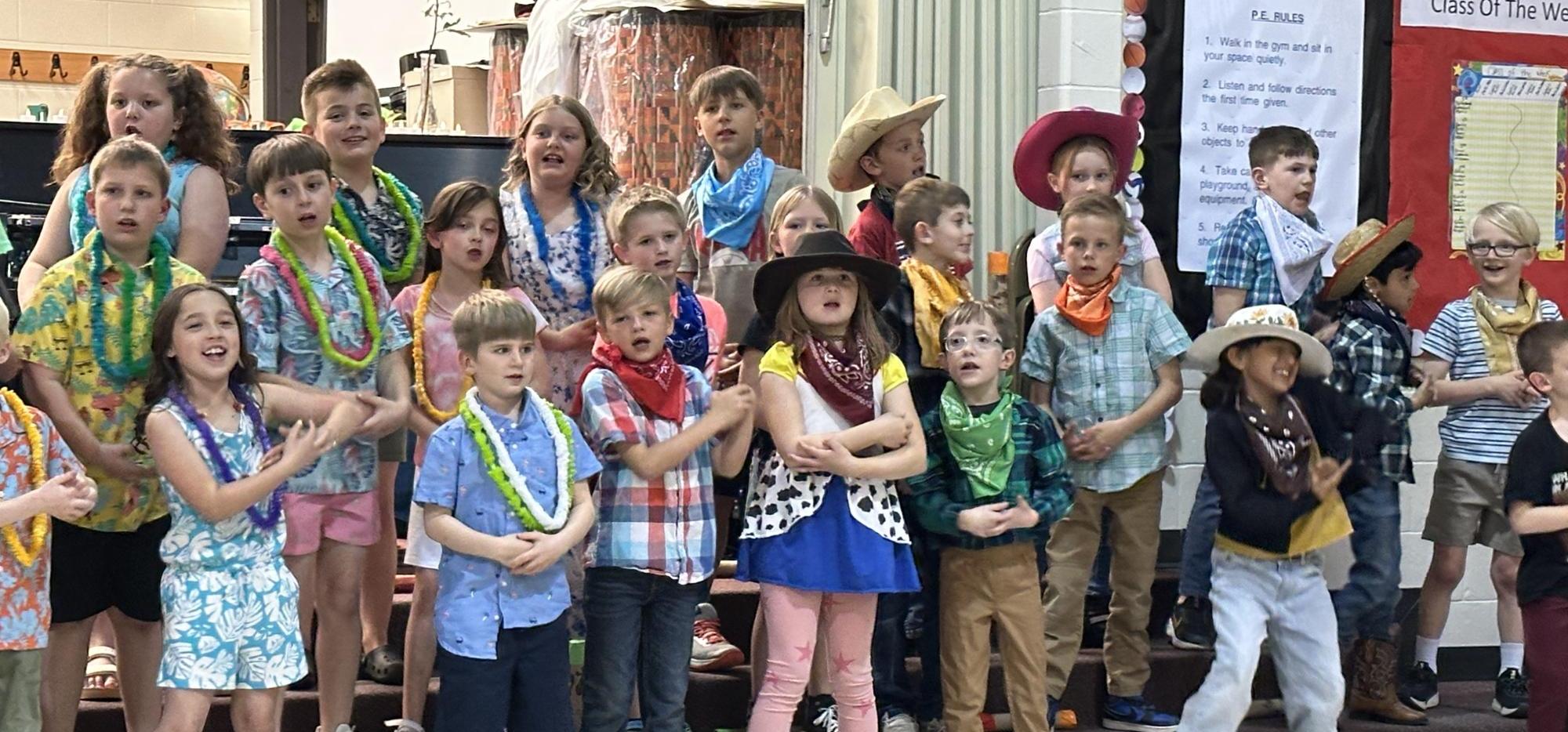student wearing leis and cowboy hats singing
